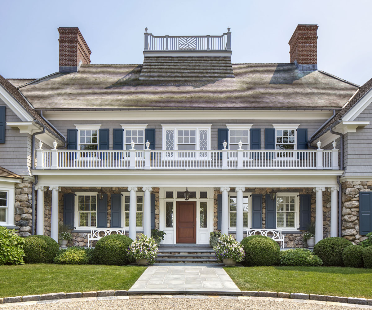 Charming Traditional Coastal Home - Greenwich, Connecticut Front Facade with Rustic Fieldstone Wall Behind a Porch Framed by Scamozzi Ionic Columns