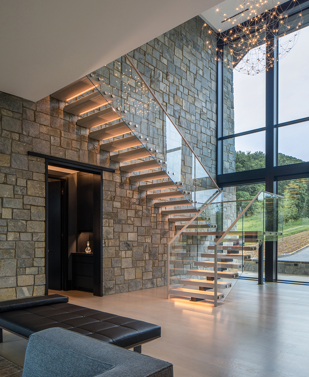 Elegant Transparent Floating Staircase Against a Stone Wall Backdrop